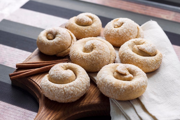 Snail sugar cookies with cinnamon on wooden board