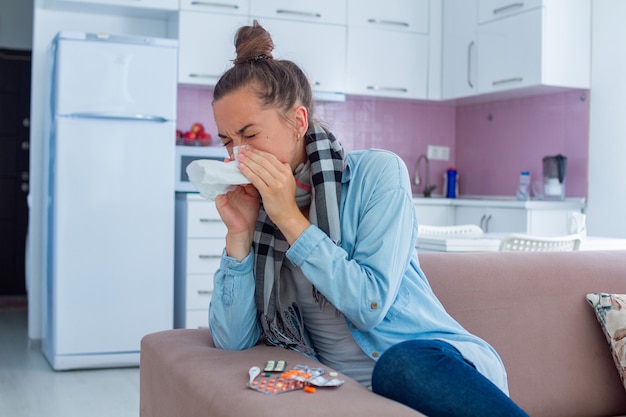 Sneezing woman in caught a cold. Flu treatment at home