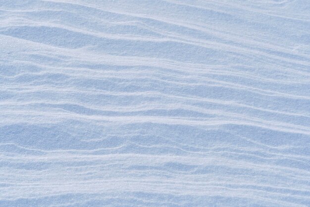 Photo snow after wind forms white canvas swirling patterns light sparkling with ice crystals unique natural texture and tranquility winter landscape