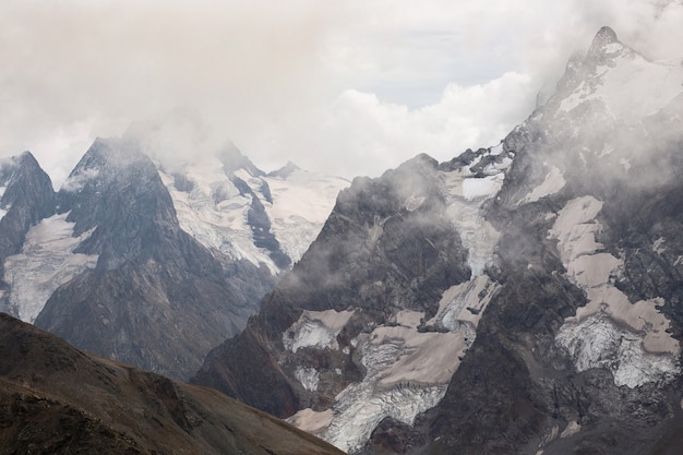 Snow capped mountain range in the clouds. Caucasus, Russia