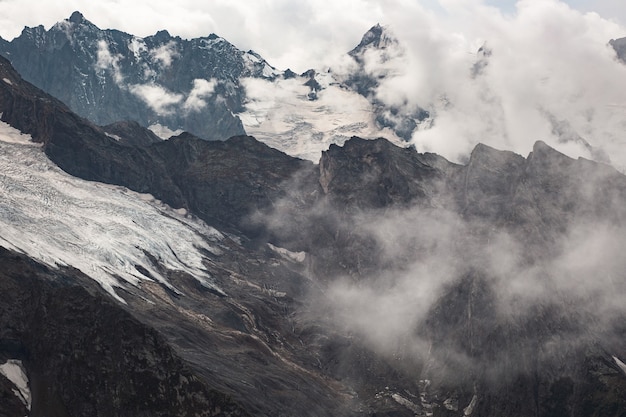 Snow capped mountain range in the clouds. Caucasus, Russia