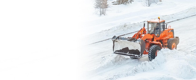 Snow clearing. Tractor clears the way after heavy snowfall. A large orange tractor removes snow