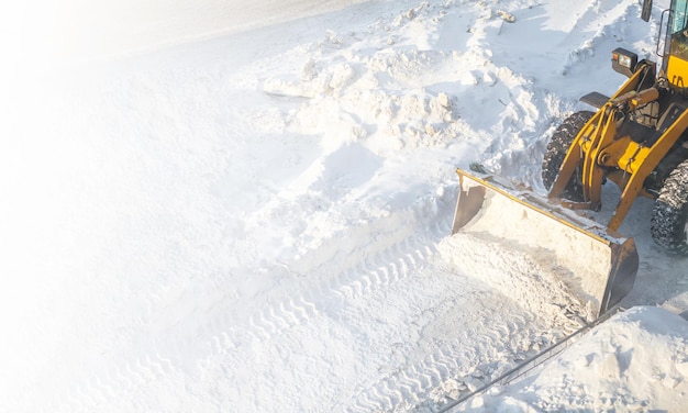 Snow clearing. Tractor clears the way after heavy snowfall. A large orange tractor removes snow