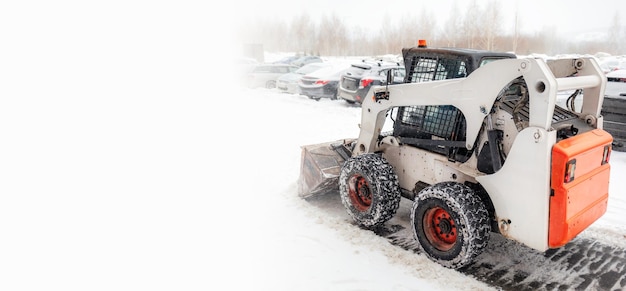 Snow clearing. Tractor clears the way after heavy snowfall. A large orange tractor removes snow