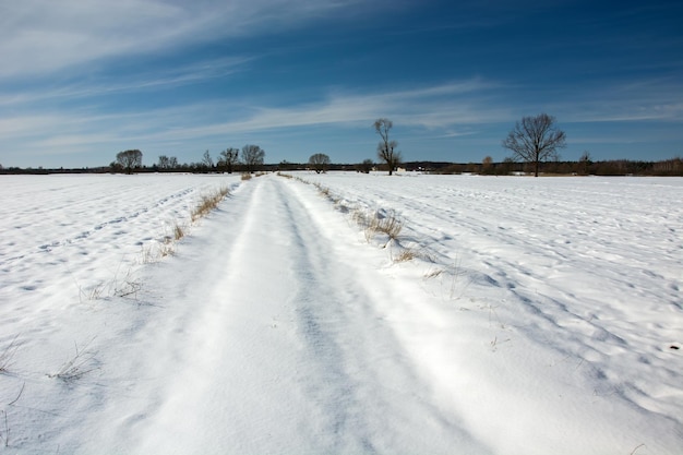 Snow covered field against sky during winter