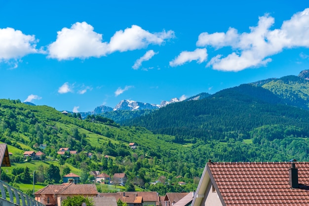 Snow-covered mountains are located near the village