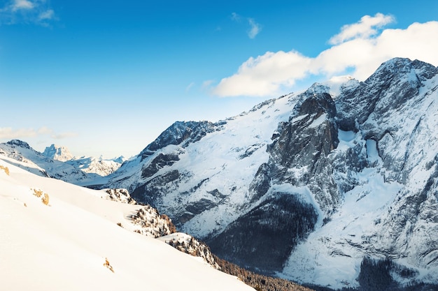 Snow-covered mountains in winter sunny day. Dolomite Alps. Val Di Fassa, Italy. Beautiful winter landscape