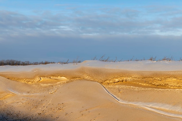 Snow covered with a thick layer of dirt and dust in the winter season very heavily polluted gray snow near the road