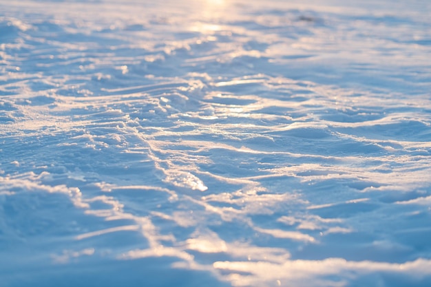 A snow crust on the frozen winter lake at sunset