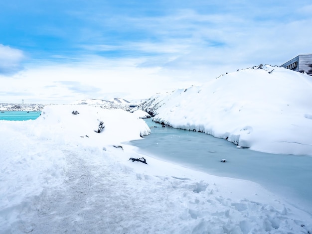 Snow field with white mountains under cloudy sky in Iceland