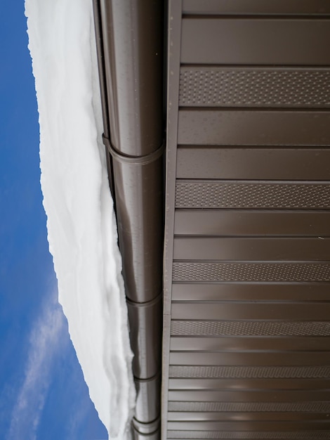 Snow hanging on the roof drainpipe The drainpipe are covered with snow