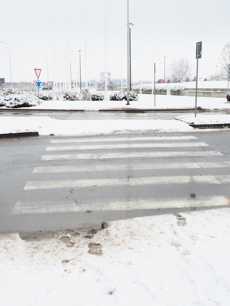 Snow ice slush and winter mud at a pedestrian crossing The air temperature is about 0 Difficult driving conditions Braking distance of the car Traffic Laws Infrastructure and road services