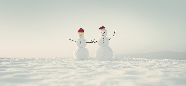 Photo snow men from snow in santa hat snowman couple outdoor happy holiday and celebration