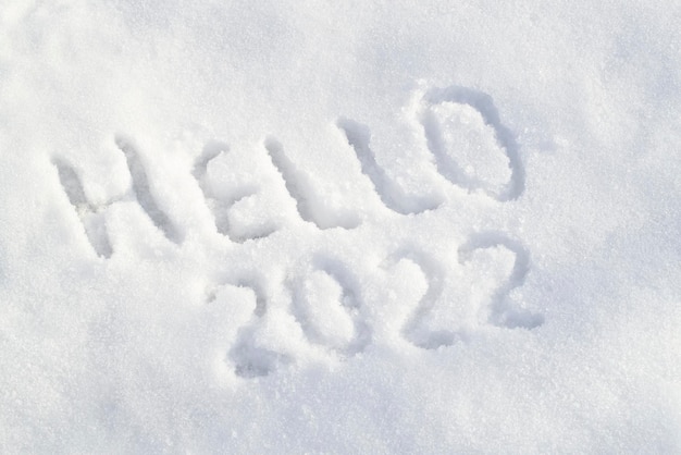 Snow surface and text hello  inscription draw on white snow happy new year  concept top view above