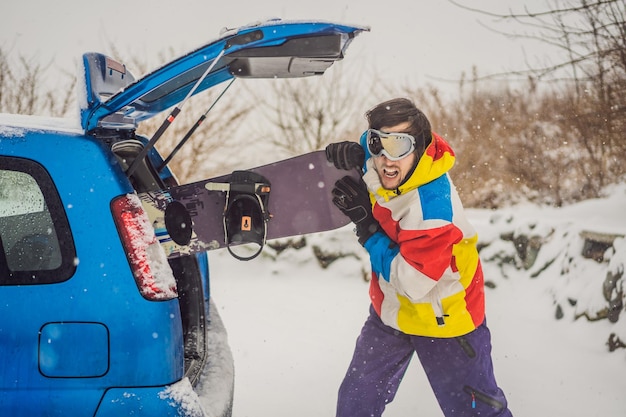 The snowboard does not fit into the car A snowboarder is trying to stick a snowboard into a car Humor fun