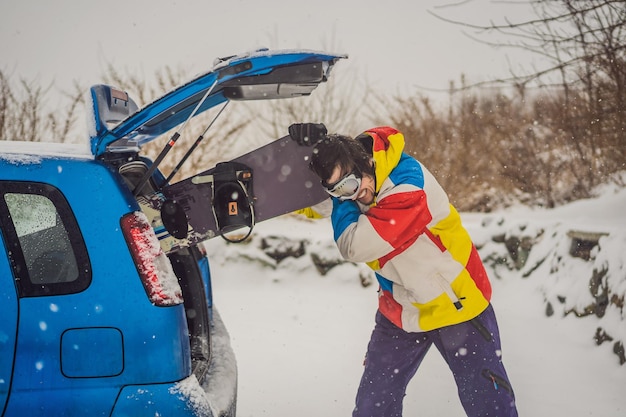 The snowboard does not fit into the car A snowboarder is trying to stick a snowboard into a car Humor fun