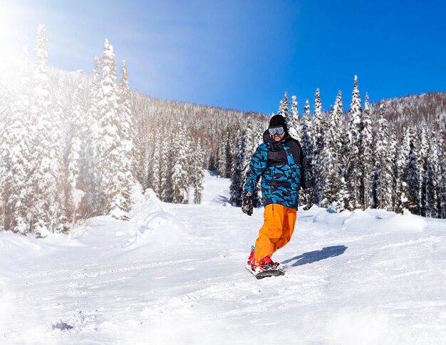 snowboarder rides down the slope on a sunny day