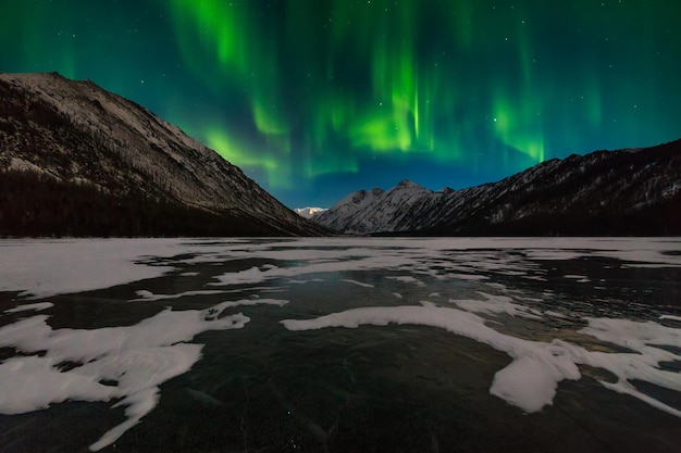 Snowcapped mountains at night under the northern lights Norway