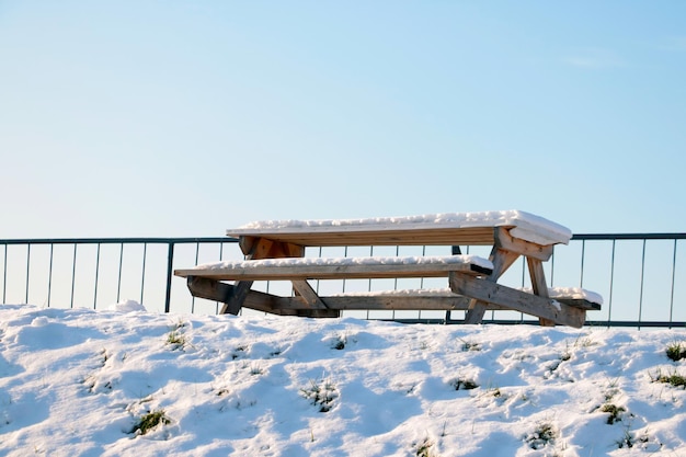 A snowcovered bench and a table in a winter park