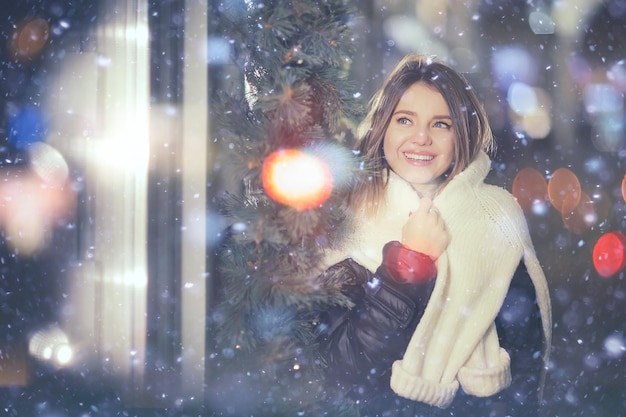 snowfall woman city christmas outside, city portrait in snowfall, young model posing in festive look