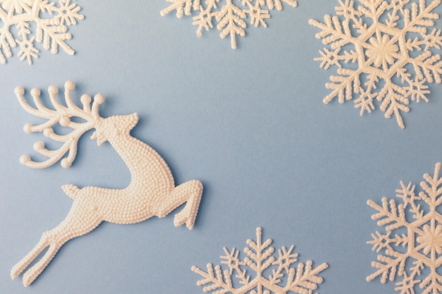 Snowflakes and deer for New Year's decor on a blue background with space for text Christmas layout