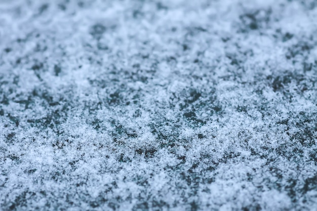 Snowflakes during the snowfall on glass surface.