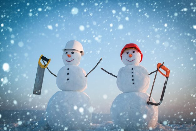 Photo snowman builder in winter in helmet