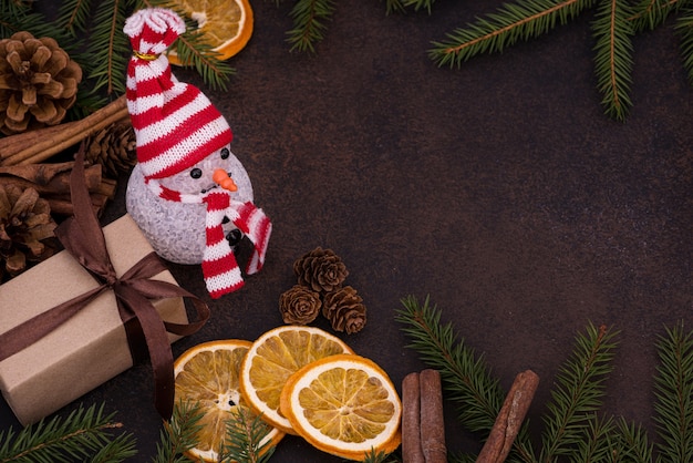 Snowman and gift on the background of Christmas decorations