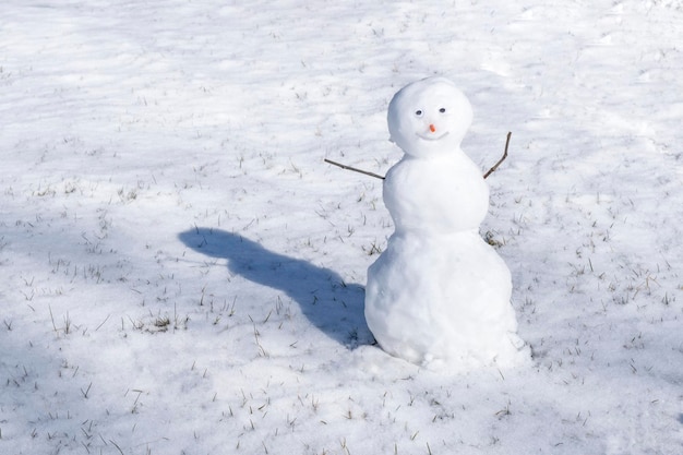 Snowman on white background Green grass growing First snow