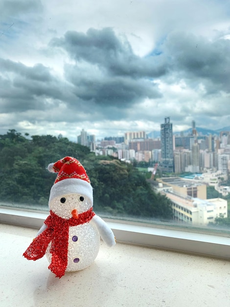 Snowman next to the window with beautiful cityscape