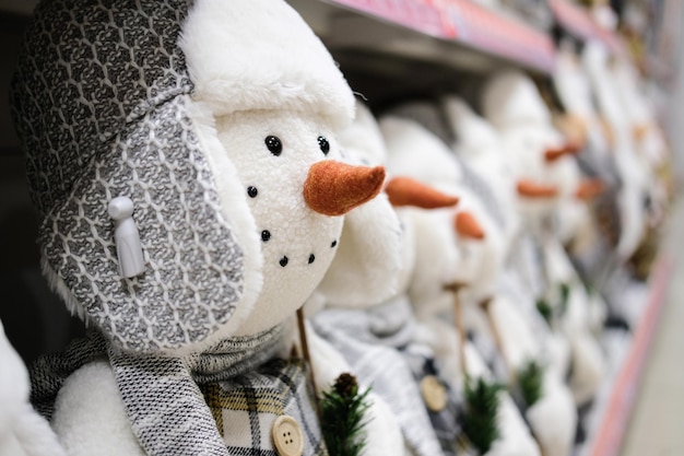 Snowmen toys stand on the counter of the store. Close-up