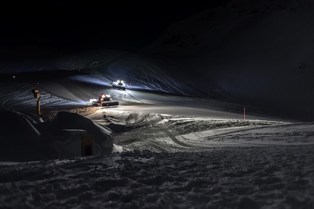 Snowmobile on ski run at night