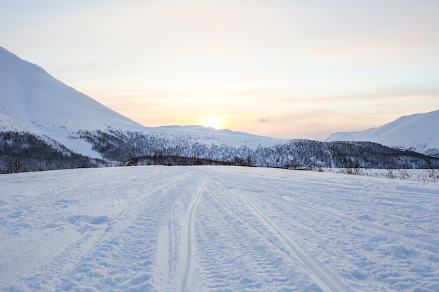 snowmobile tracks on the snow in the mountains