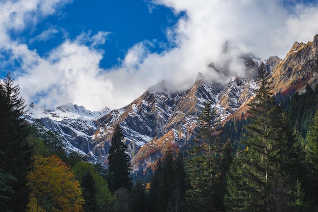 Snowy And Cloudy Peaks In Autumn