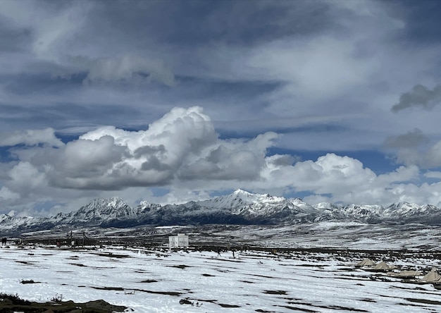 A snowy landscape with mountains in the background