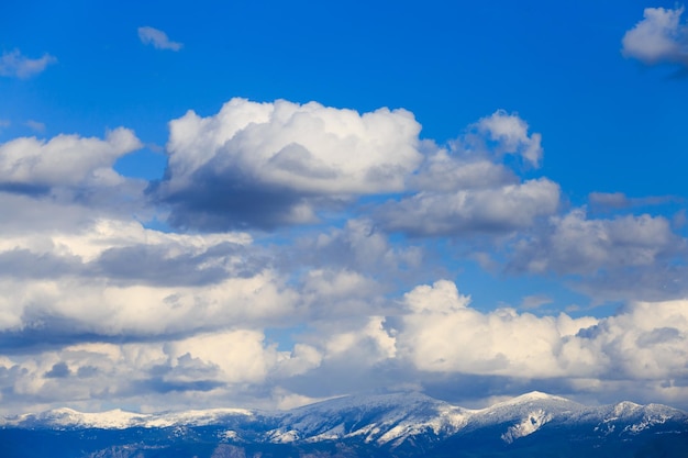 Snowy mountain range with blue sky and clouds