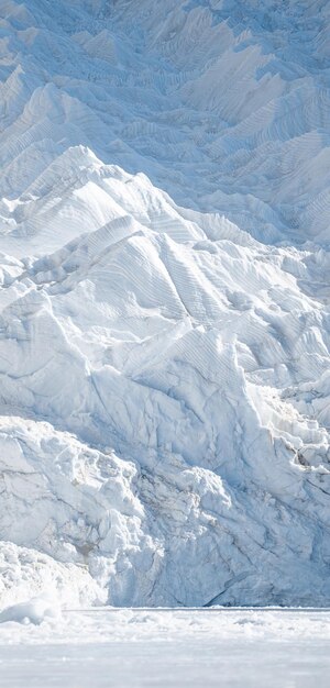 A snowy mountain with a snow covered mountain in the background