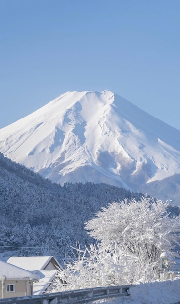 A snowy mountain with a snow covered mountain in the background