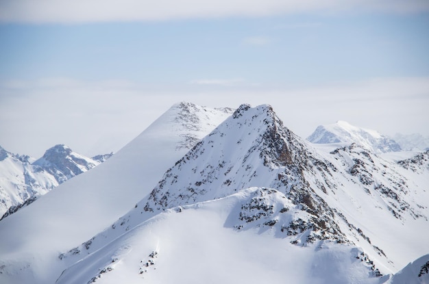 Snowy mountains peaks in the clouds blue sky caucasus