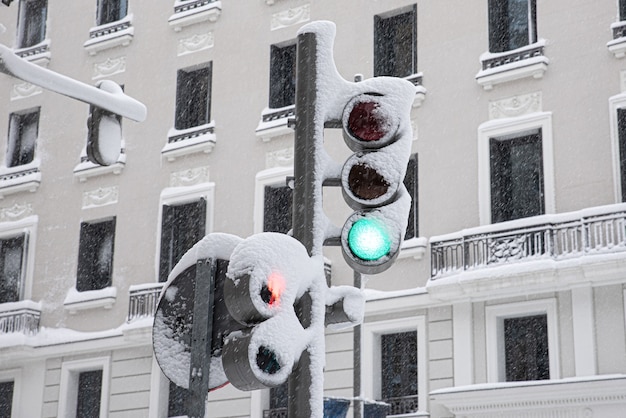 Snowy traffic light on green on a snowy winter day