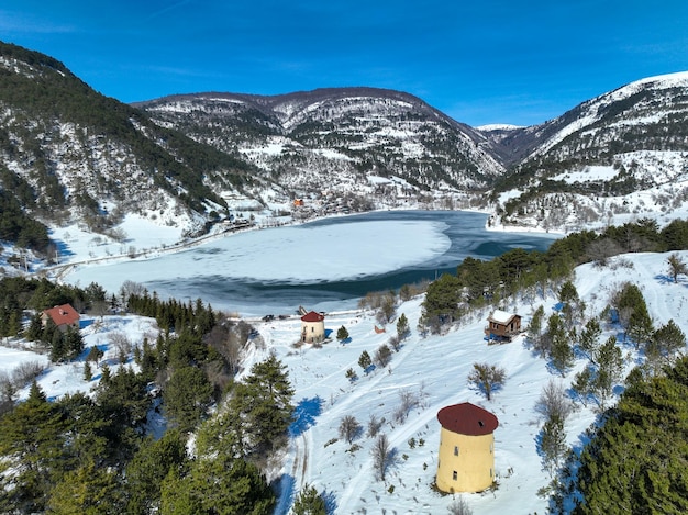 Snowy winter landscape of Goynuk Cubuk lake and windmills with aerial drone. Bolu - Turkey.