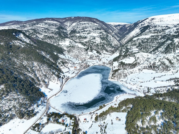 Snowy winter landscape of Goynuk Cubuk lake and windmills with aerial drone. Bolu - Turkey.