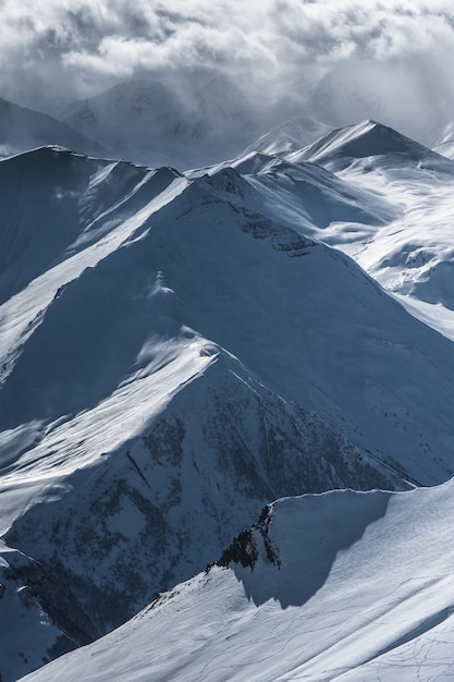 Snowy winter mountains in sun day. Caucasus Mountains, Georgia, from ski resort Gudauri