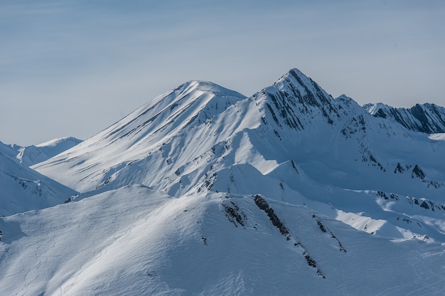 Snowy winter mountains in sun day. Caucasus Mountains, Georgia, from ski resort Gudauri