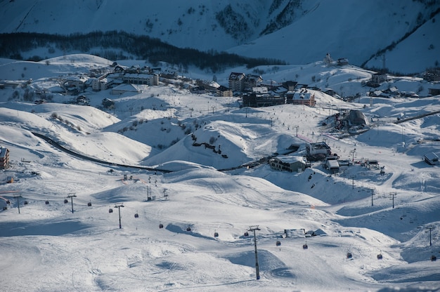 Snowy winter mountains in sun day. Caucasus Mountains, Georgia, from ski resort Gudauri