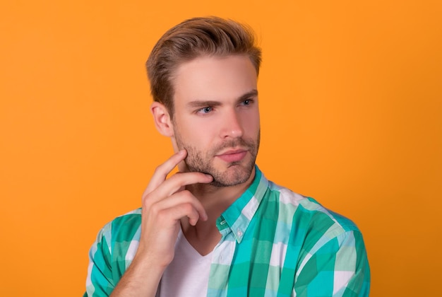 So serious Mans portrait yellow background Portrait of guy with straight face Handsome dude