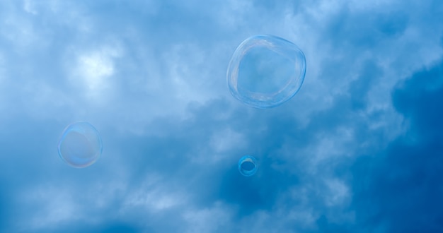 Soap bubble against the background of a stormy dark blue sky. High quality photo