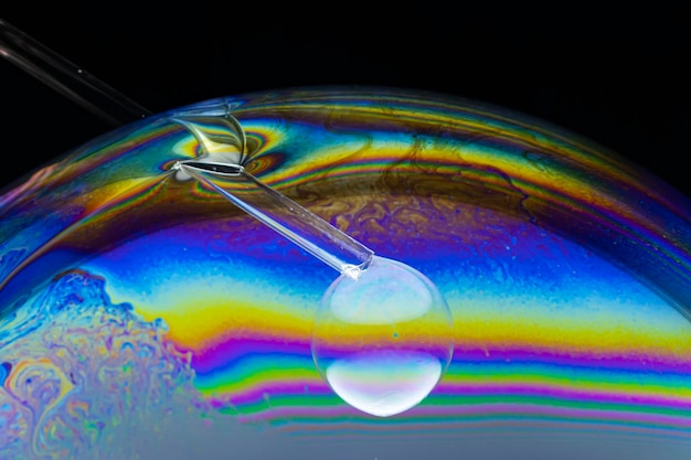 Soap bubble created inside another one with plastic tube