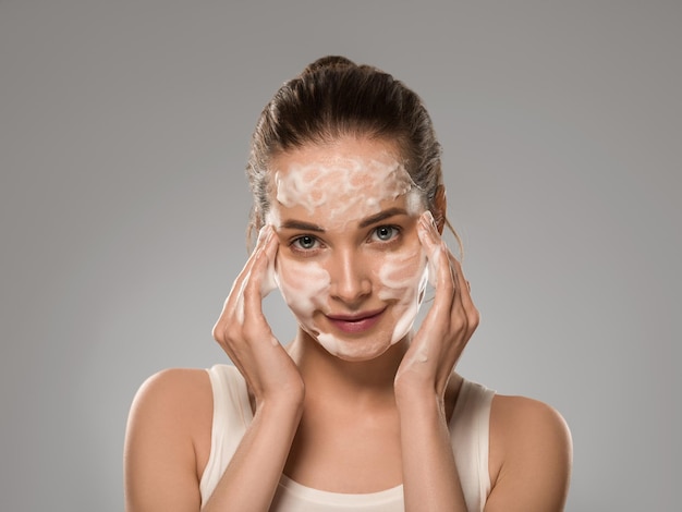 Soap face woman clean skin beauty. Color background. Gray