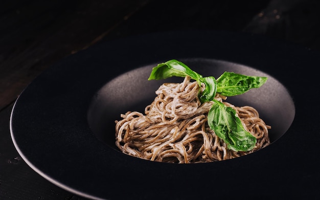 Soba noodles on a black plate